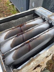 A close-up view of a rusted and cracked furnace heat exchanger, indicating a need for repair by Sizemore Heating & Air, LLC in Chapel Hill, NC