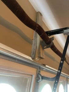 A close-up of a rusted garage door torsion spring system in need of repair by Swift Garage Door in Nashville, TN.