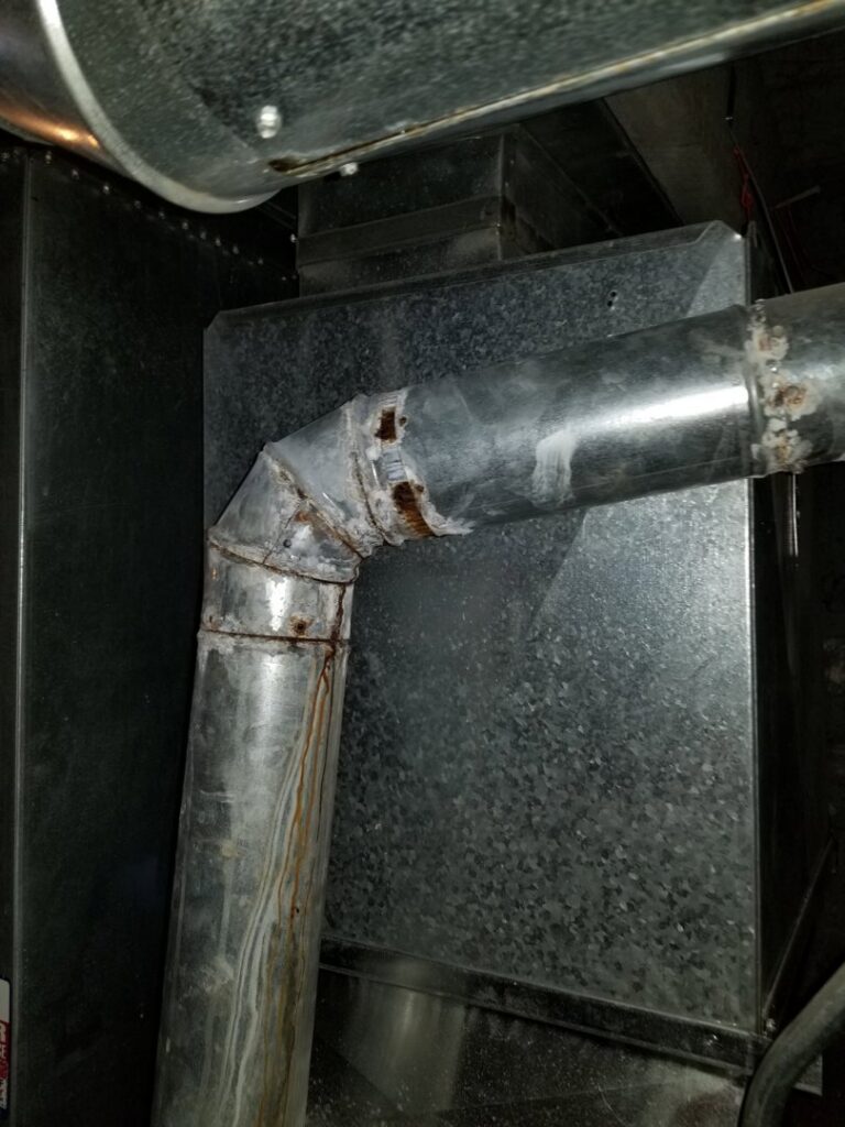 Rusted HVAC ductwork connected to a furnace, indicating a need for repair or replacement by HVAC Royal Service Inc in Chicago, IL.