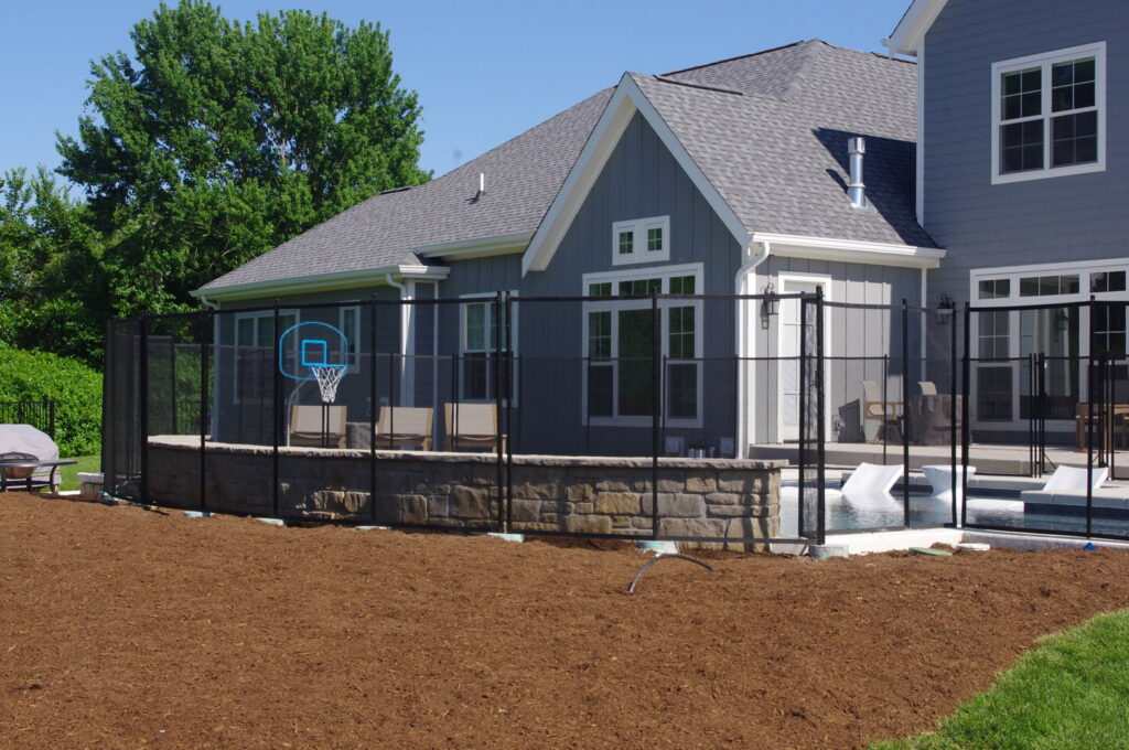 A rustic split rail fence running alongside a pond in a rural setting, installed by Custom Design Fence & Deck, Inc. in Ofallon, MO