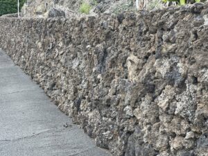 A rustic stone rockwall providing a natural boundary, built by Fence, Gates and Rockwalls in Kailua-Kona, HI