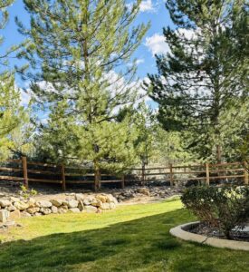 A rustic wooden fence installed in a beautifully landscaped backyard by Mule Fence Inc. in Sparks, NV.