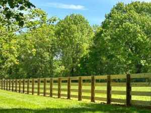 A rustic wood rail fence installed in a green field by Frontier Fence LLC Bowling Green,Ky