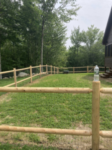 A rustic wooden fence with wire mesh installed in a green grassy backyard by Profence in Leander, TX.