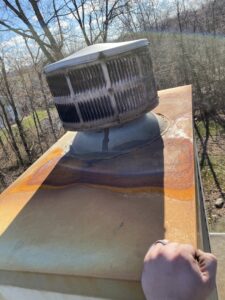 A rusty and weathered chimney cap or vent on a roof, indicating a need for inspection or repair by Midtown Chimney Sweeps in Golden, CO.