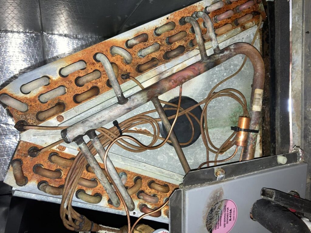 The interior of an HVAC unit showing rusty coils and wiring, indicating maintenance or inspection by Star Quality Air Duct Cleaning in Silver Spring, MD.