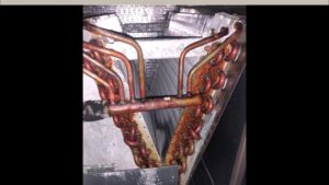A close-up view of a rusty HVAC evaporator coil, indicating a need for service from Clean Air Solutions in Gaithersburg, MD.