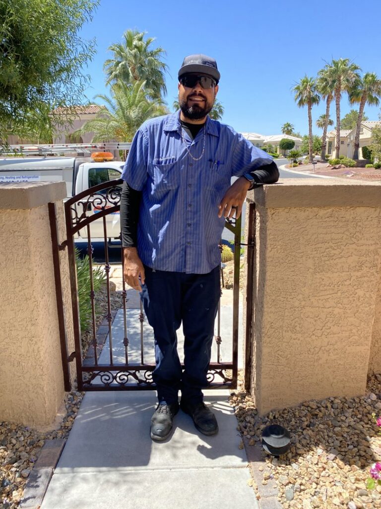 An RW Mechanical Inc. HVAC technician standing on a residential property in Las Vegas, NV.