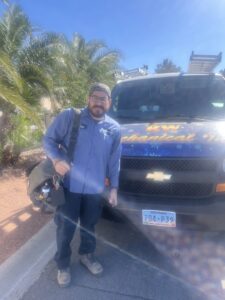An RW Mechanical Inc. HVAC technician standing in front of a branded service van in Las Vegas, NV.