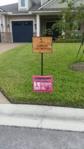 A Safari Termite and Pest Control sign placed beneath a "Yard of the Month" award in Jacksonville, FL.