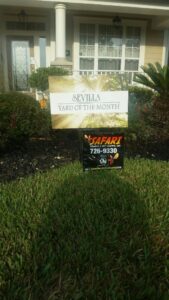 A Safari Termite and Pest Control sign displayed beneath a "Yard of the Month" award in Jacksonville, FL.