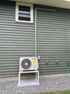 A Samsung mini-split outdoor unit professionally installed on a stand by Laird's HVAC in Auburn, ME.