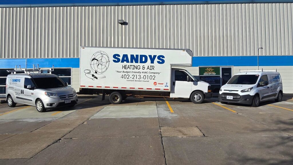The Sandys Heating & Air service fleet vehicles parked outside their business in Papillion, NE.