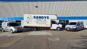 The Sandys Heating & Air service fleet vehicles parked outside their business in Papillion, NE.
