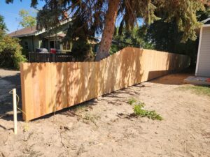 A newly installed scalloped top wooden privacy fence in a backyard by Josey's Fencing LLC in Caldwell, ID.