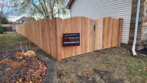 Scalloped wood privacy fence with a gate installed by All Terrain Fence LLC in Waukegan, IL