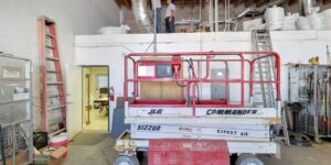 A JLG Commander scissor lift in the Expert Air Conditioning & Heating workshop, used for high-reach HVAC tasks in Las Vegas, NV.