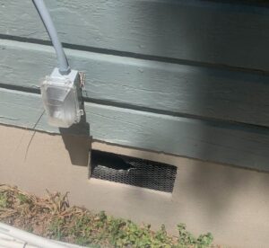 A screened foundation vent on a house, a common area for pest exclusion by Barefoot Mosquito & Pest Control in Austin, TX.