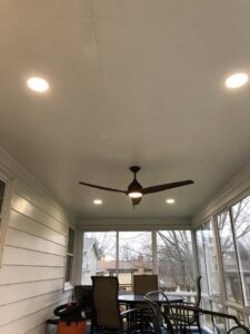 A screened-in porch featuring a newly installed ceiling fan and recessed lighting by Surge Electric LLC in Youngstown, OH.