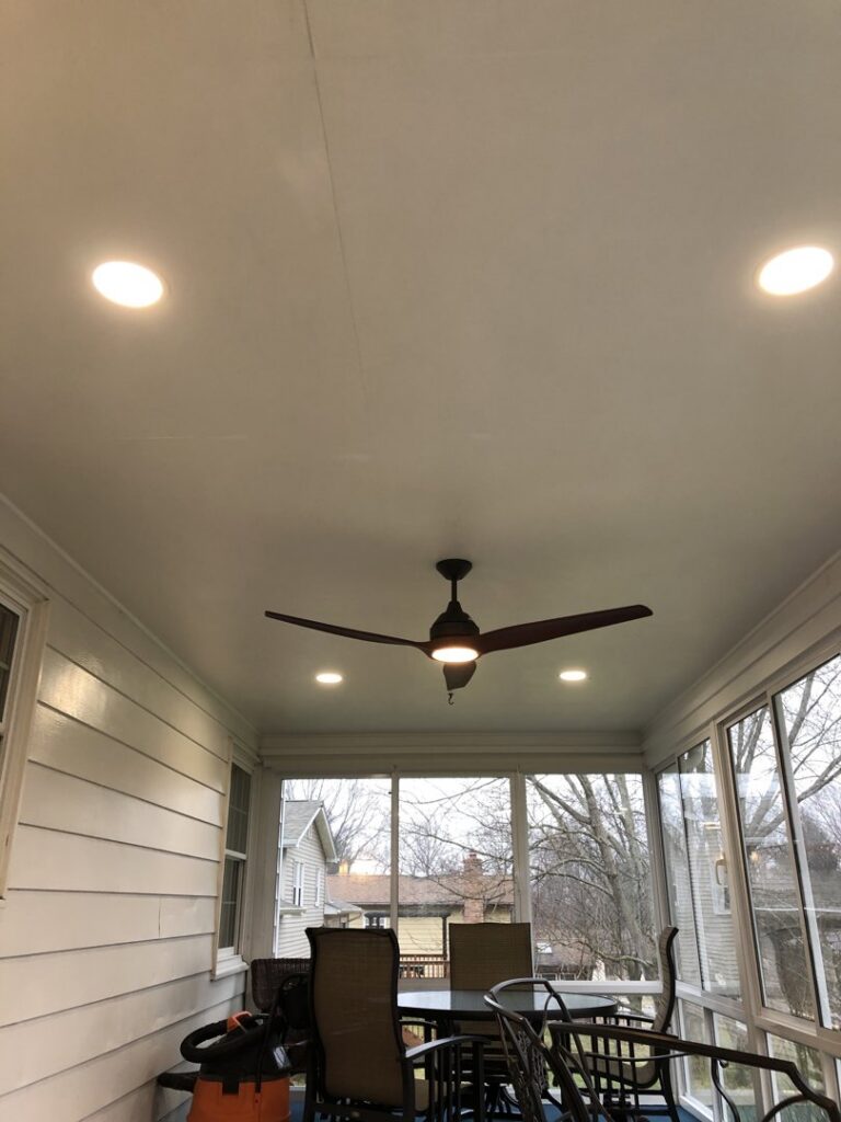 A screened-in porch featuring a newly installed ceiling fan and recessed lighting by Surge Electric LLC in Youngstown, OH.