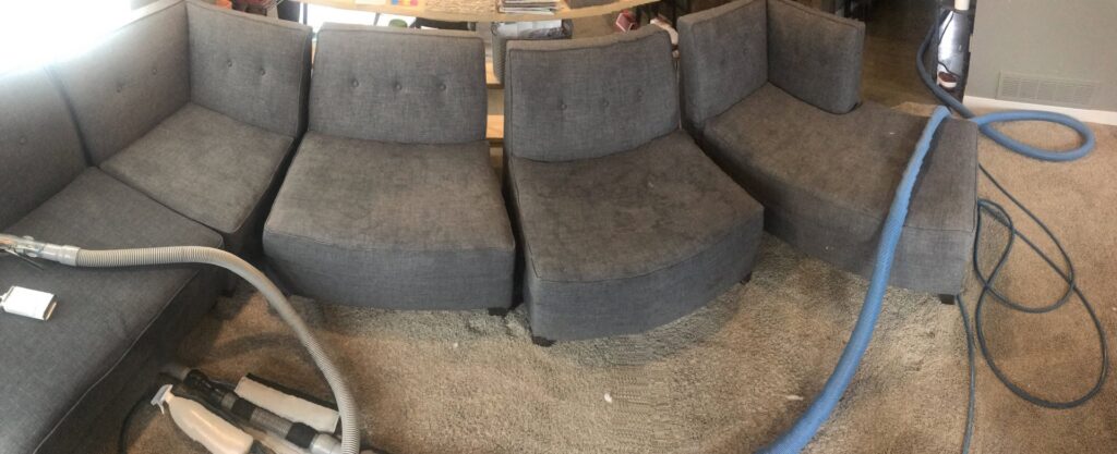 A panoramic view of a sectional sofa and surrounding carpet undergoing professional cleaning by Elementscarpetcleaning.net in Omaha, NE.