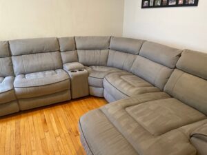 A large sectional sofa with visible cleaning lines on the upholstery, demonstrating BeClean's cleaning service in Charlotte, NC.