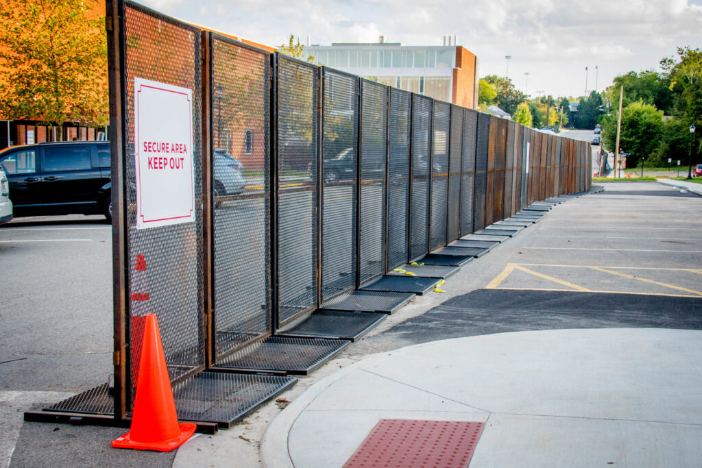 Long line of temporary security fencing with a 'Secure Area Keep Out' sign by Checkmate Global in Frederick, MD.