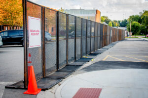 Long line of temporary security fencing with a 'Secure Area Keep Out' sign by Checkmate Global in Frederick, MD.