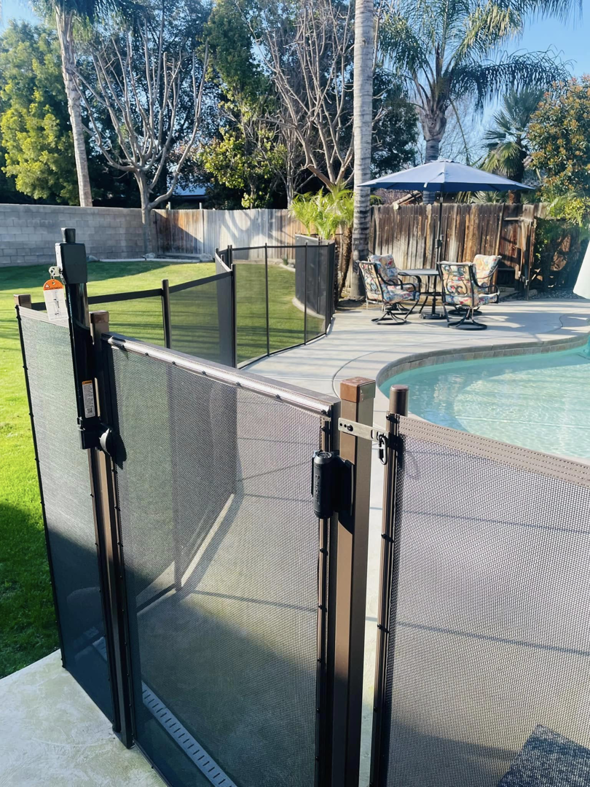 A secure pool enclosure with a self-latching gate, providing safety in a sunny backyard by A Safe Pool Enclosures in Bakersfield, CA.