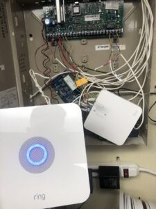 An open security alarm panel with Ring devices and wiring, installed by PTech Installs in Columbus, GA.