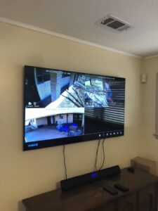 A wall-mounted TV displaying security camera feeds, installed by Greater Baton Rouge Electric in Baton Rouge, LA.