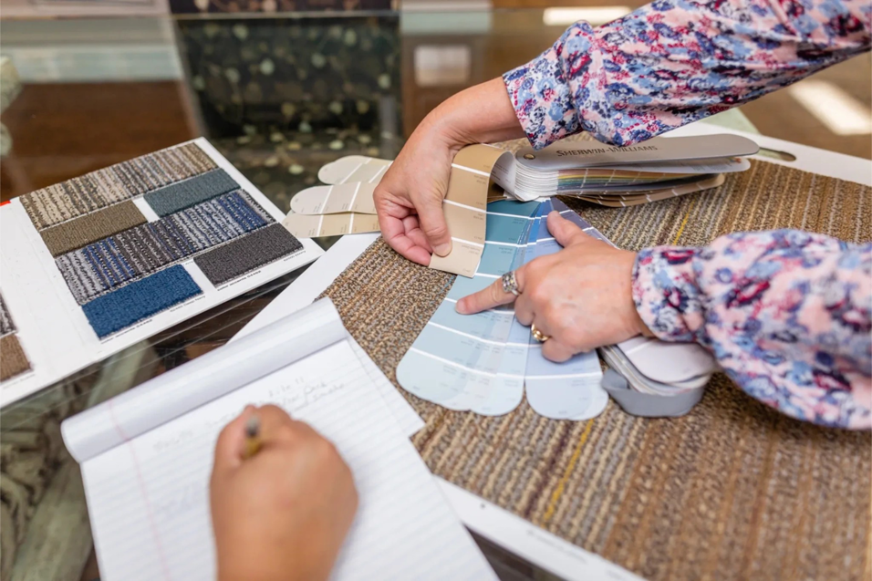 Hands selecting carpet samples and color swatches at McLarrin Flooring & Counter Tops in Monroe, LA