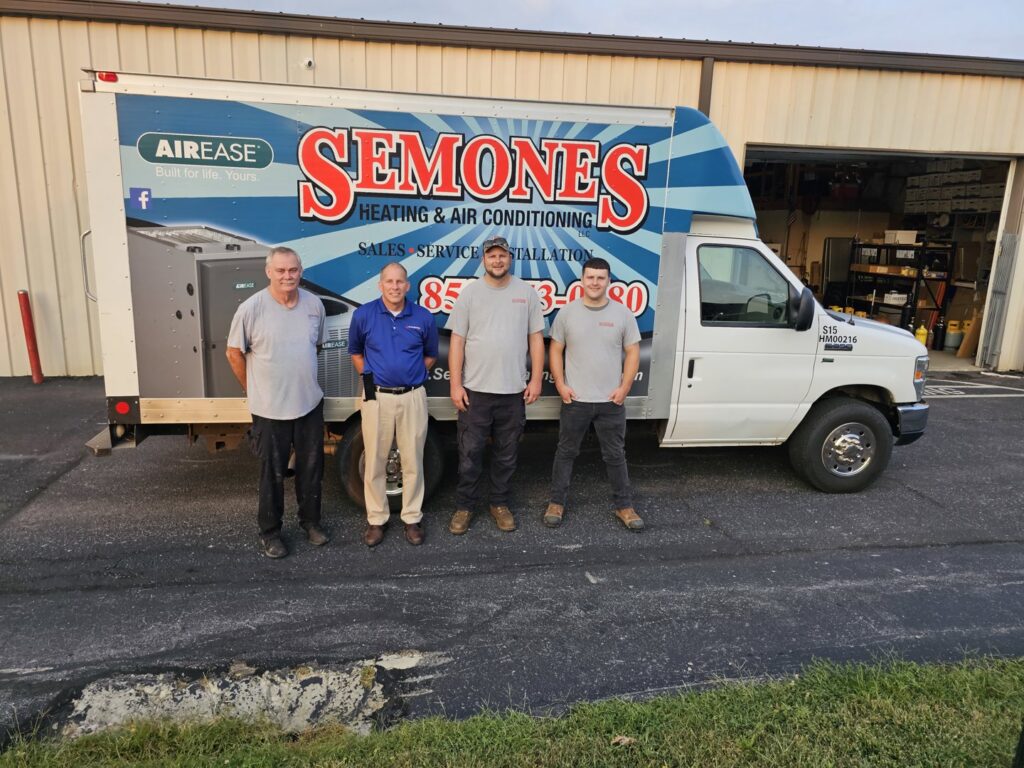 Four HVAC technicians from Semones Heating & Air Conditioning standing by their service truck for Leap Partners in Greensboro, NC.