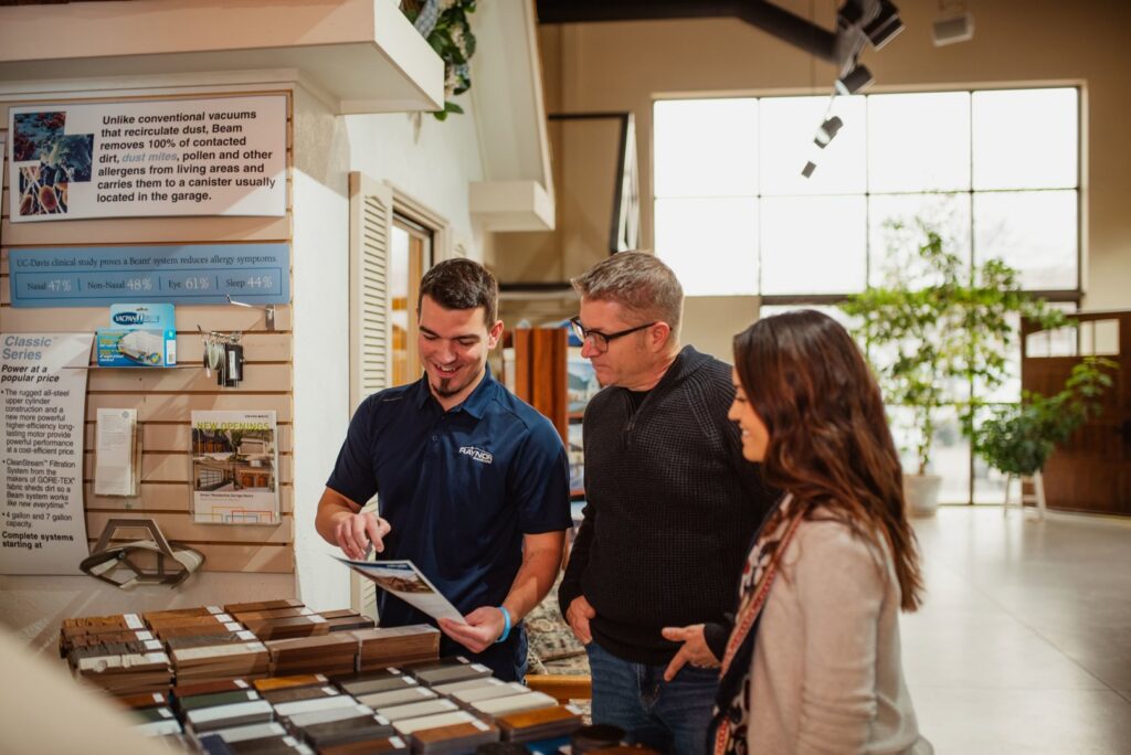 A Front Range Raynor Garage Door & Service representative showing garage door samples to a couple in Fort Collins, CO.