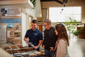 A Front Range Raynor Garage Door & Service representative showing garage door samples to a couple in Fort Collins, CO.