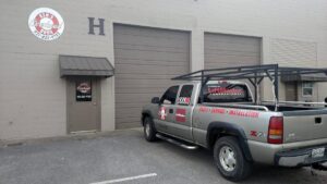 Ken's Overhead Door service truck parked in front of a commercial building with roll-up garage doors in Clarksville, TN.