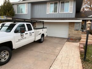 A Colorado Garage Door Guy service truck parked at a residential job site in Aurora, CO.