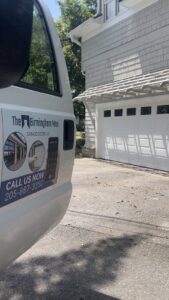 The Birmingham Man Garage Doors service truck parked at a job site with a white garage door in Birmingham, AL.