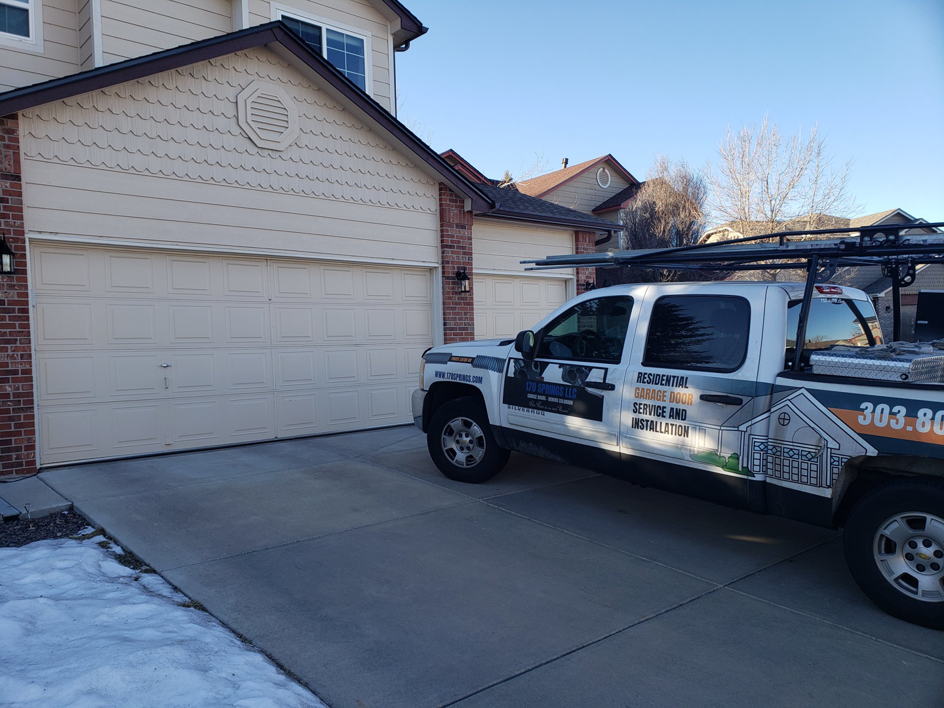 A 170 Springs LLC Garage Doors service truck parked at a residential garage door job site in Aurora, CO