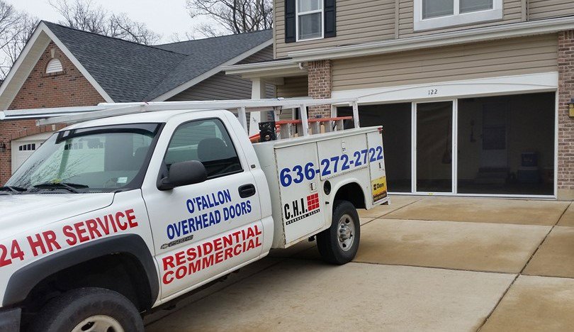 A service truck from O'Fallon Overhead Doors parked in front of a home with a newly installed garage door screen in O'Fallon, MO.