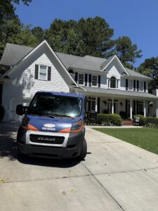 Advanced Cleaning Systems service van parked in front of a large, traditional house in Atlanta, GA.