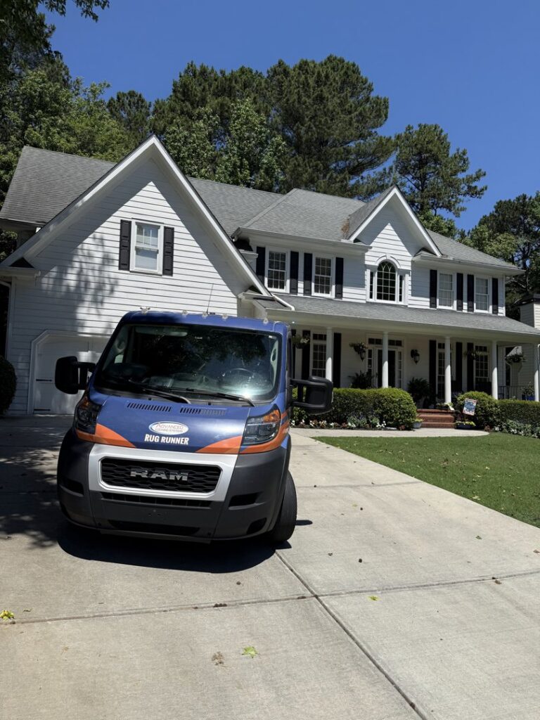 Advanced Cleaning Systems service van parked in front of a large, traditional house in Atlanta, GA.