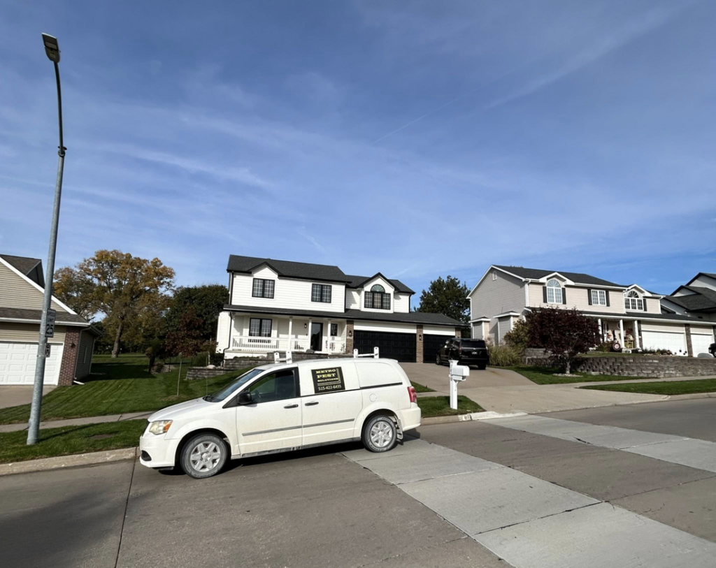 A Metro Pest Solutions service van parked at a residential property for pest control in West Des Moines, IA.