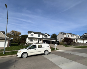 A Metro Pest Solutions service van parked at a residential property for pest control in West Des Moines, IA.