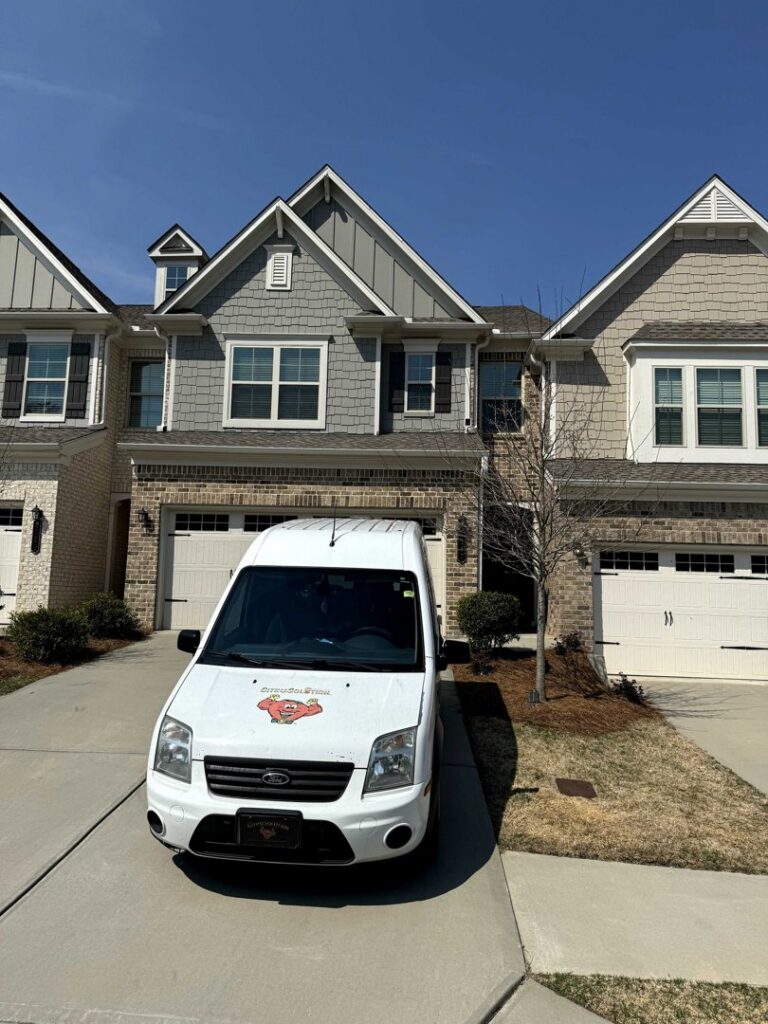 A Johns Creek Carpet Cleaner service van parked in front of a townhouse, ready for a carpet cleaning job in Johns Creek, GA.