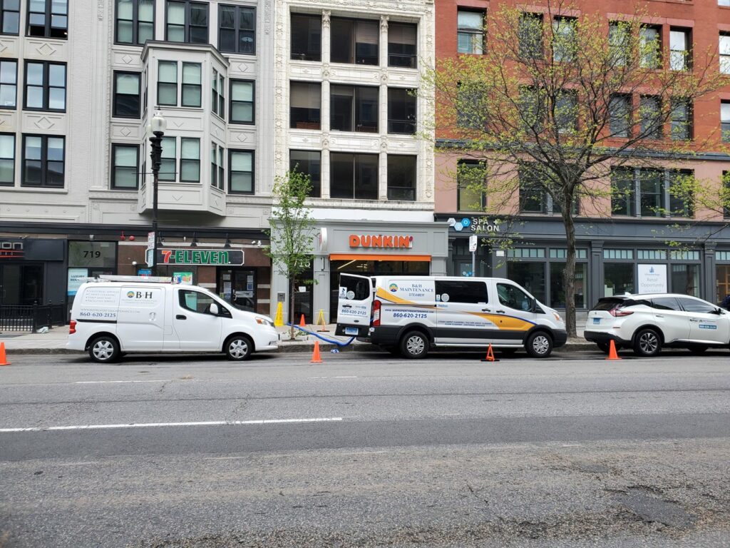 B&H Property Maintenance LLC service vans with hoses deployed for a carpet cleaning job in Middletown, CT.