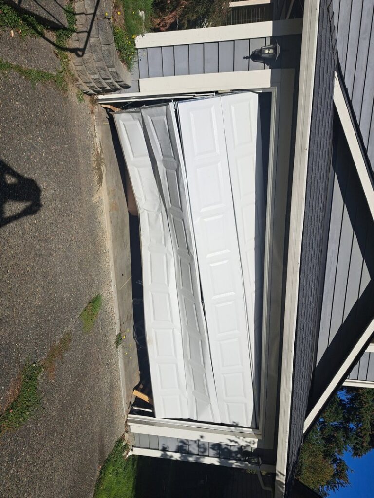 A severely damaged and collapsed garage door requiring urgent repair from Steadfast Garage Door Services LLC in Federal Way, WA.