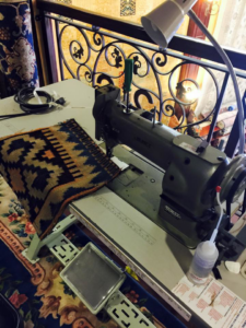 A heavy-duty sewing machine used for rug repair or binding services at Tousi Rugs in Los Angeles, CA.