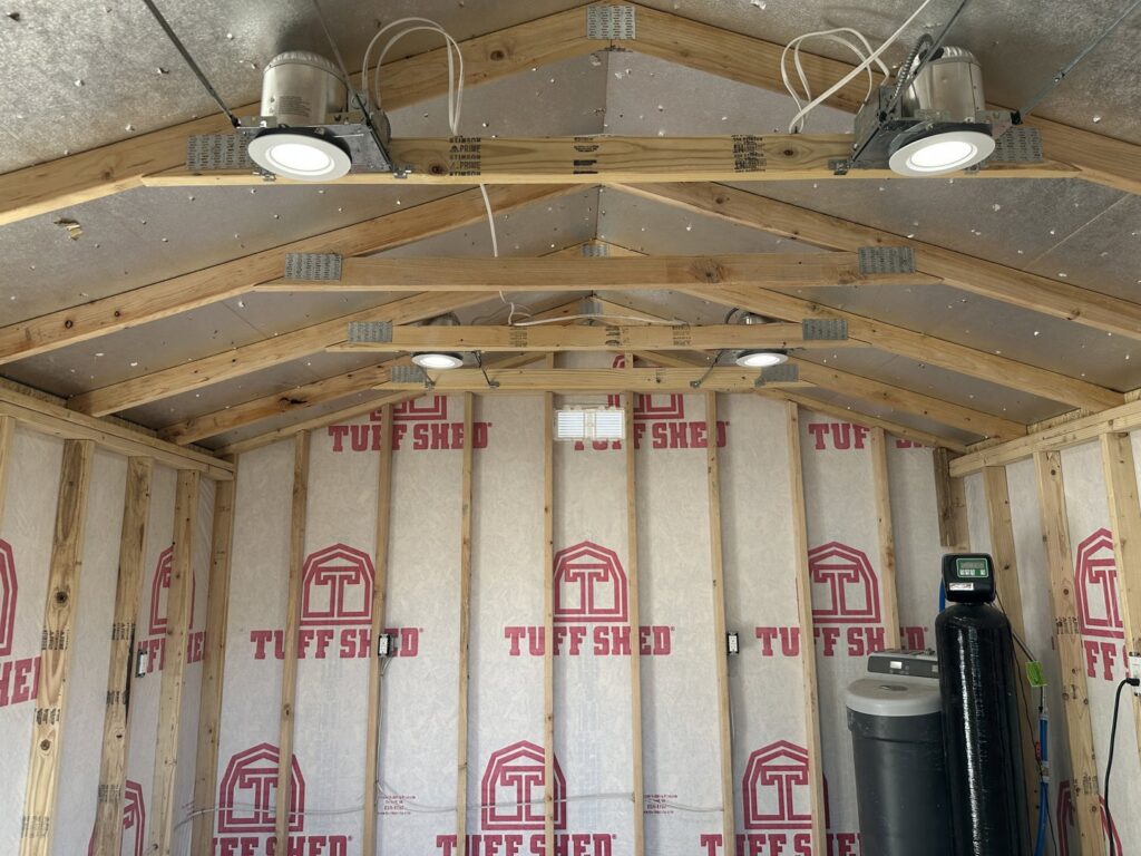 Interior of a shed showing electrical wiring, recessed lighting, and outlets installed by Sparks By Rabbit LLC in Scottsdale, AZ.