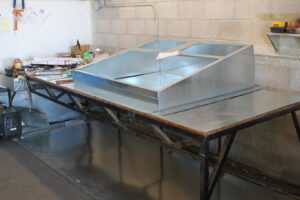 Custom sheet metal ductwork being fabricated on a workbench by Expert Air Conditioning & Heating in Las Vegas, NV.